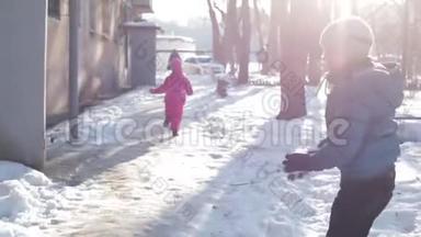 孩子们在阳光明媚的冬天在雪地里散步。 男孩在雪地里奔跑